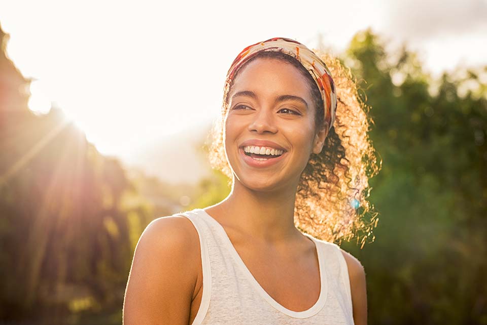 Young african woman smiling at sunset